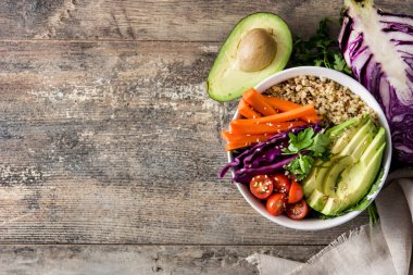 Vegan Buda kase taze çiğ sebze ve ahşap masa üzerinde quinoa ile. Üstten görünüm. Boşaltmak
