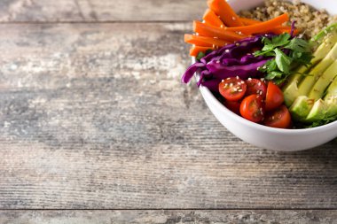 Vegan Buda kase taze çiğ sebze ve ahşap masa üzerinde quinoa ile. Üstten görünüm. Boşaltmak