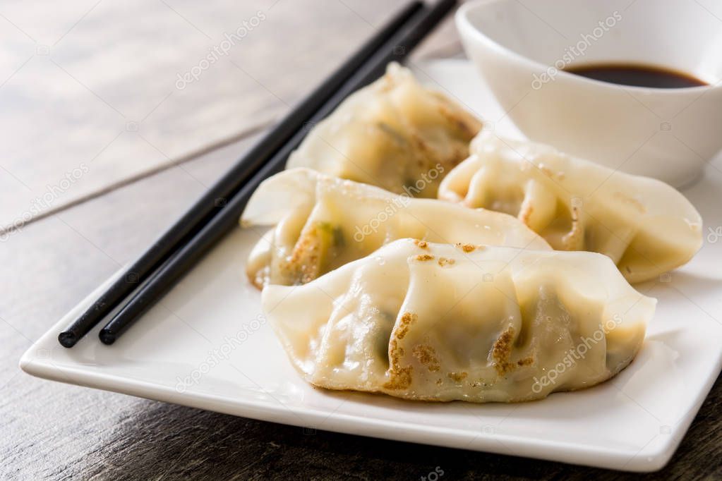 Dumplings or gyoza and soy sauce on wooden table. Close up