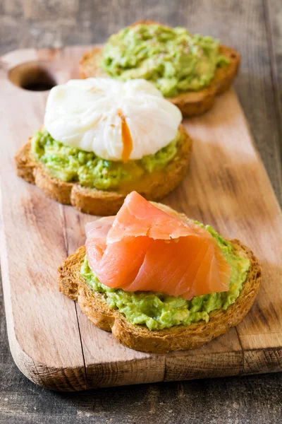 Toasted breads with poached eggs, avocado and salmon