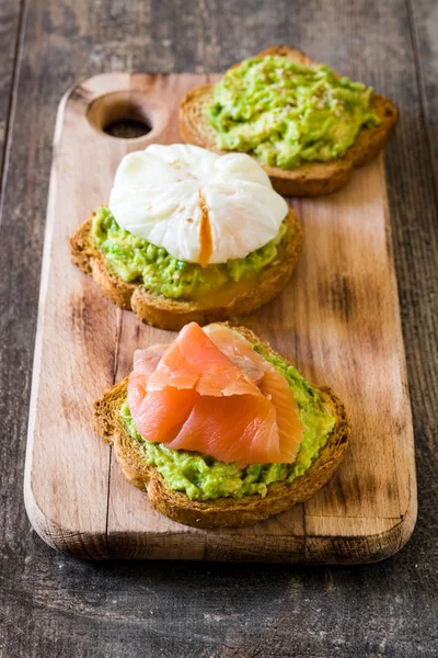 Toasted breads with poached eggs, avocado and salmon