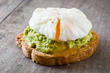 Ahşap masa haşlanmış yumurta ile avokado tost kapatın