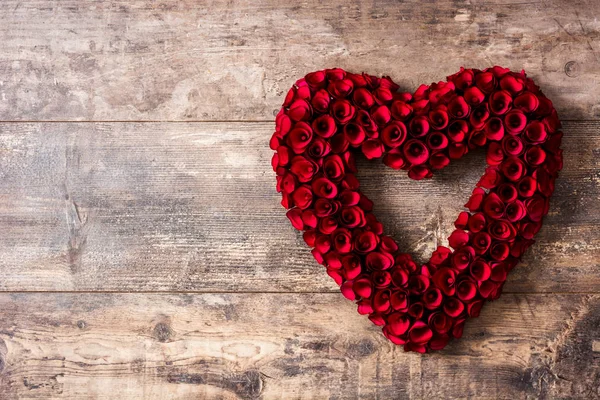 バレンタインの日に木のテーブルに赤いバラから作られた心 Copyspace — ストック写真