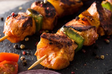 Ahşap masa üzerinde sebzeli tavuk şiş kebap. Yakın çekim