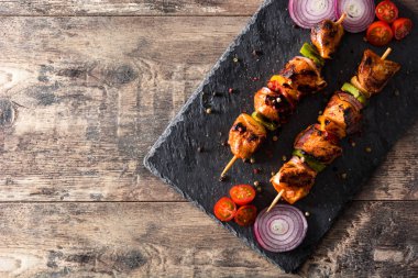Ahşap masa üzerinde sebzeli tavuk şiş kebap. Üstten görünüm. Boşaltmak