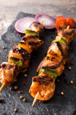 Ahşap masa üzerinde sebzeli tavuk şiş