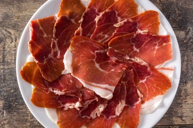 İspanyol serrano jambonu veya prosciutto plaka üzerinde ahşap masa ahşap masa üzerinde. Üstten görünüm. 