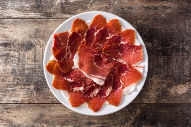 İspanyol serrano jambonu veya prosciutto plaka üzerinde ahşap masa ahşap masa üzerinde. Üstten görünüm. 