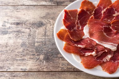 İspanyol serrano jambonu veya prosciutto plaka üzerinde ahşap masa ahşap masa üzerinde. Üstten görünüm. Boşaltmak