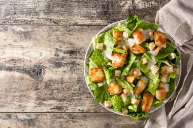 Sezar salatası marul, tavuk ve kruton ahşap masa üzerinde. Üstten Görünüm. Boşaltmak