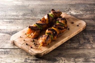 Ahşap masa üzerinde sebzeli tavuk şiş