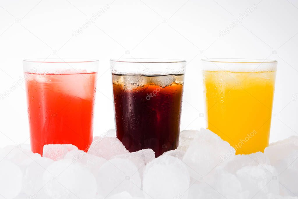 Colorful soft drinks for summer with ice cubes on white background