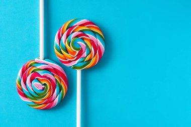 Mavi arka plan üzerinde renkli lolipop. Boşaltmak
