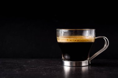 Kahve cam ve siyah arka plan üzerine kahve tahıl. Boşaltmak