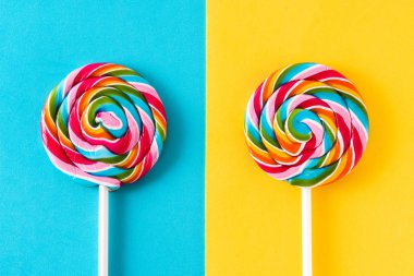 Mavi ve sarı arka plan üzerinde renkli lolipop.