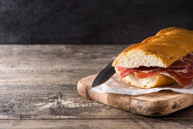 İspanyol serrano Jambonlu sandviç ahşap masa üzerinde. Boşaltmak