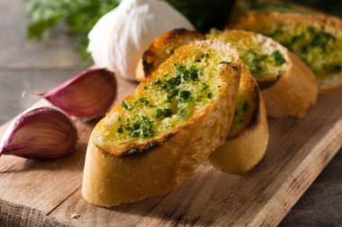 Garlic breads slice and ingredients on wooden table. Close up clipart