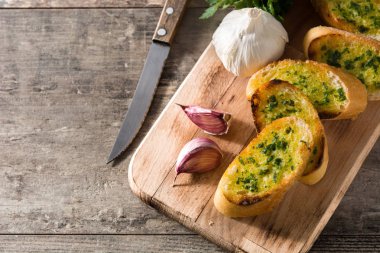 Sarımsak ekmek dilimi ve malzemeler ahşap masa üzerinde. Üstten Görünüm. Boşaltmak