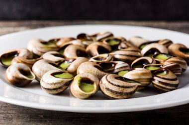 Escargots de Bourgogne. Salyangoz otlar ve sarımsak tereyağı bir plaka üzerinde. Yakın çekim