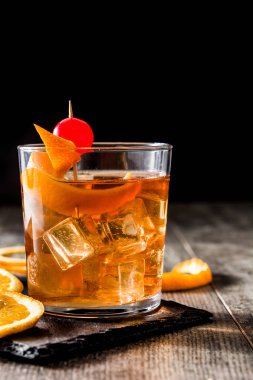 Eski ahşap masanın üzerine portakal ve vişne kokteyli moda