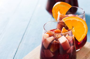Mavi ahşap masada cam kırmızı şarap Sangria. Boşaltmak