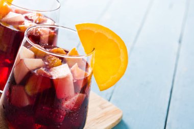 Mavi ahşap masada cam kırmızı şarap Sangria. Boşaltmak