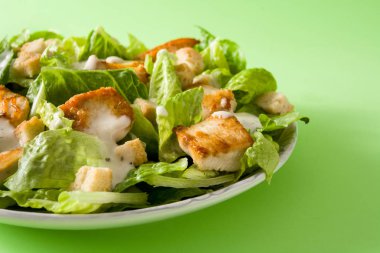 Yeşil arka planda marul, tavuk ve kruton ile Sezar salatası