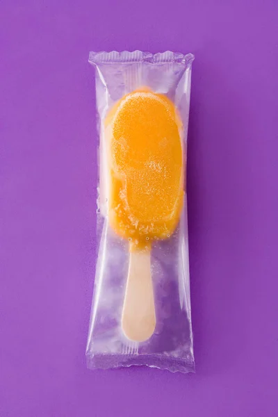 Orangefarbenes Eis Stiel Auf Violettem Hintergrund — Stockfoto