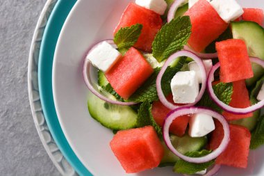 beyaz peynir, nane, soğan ve gri arka plan üzerinde salatalık ile karpuz salatası. Yakın çekim