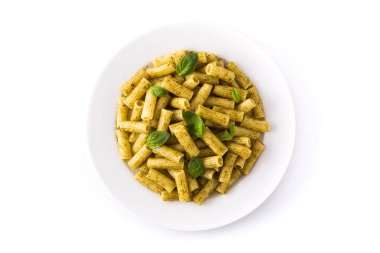 Beyaz arka plan üzerinde izole bir tabak üzerinde pesto sos lu penne makarna ve fesleğen. Üstte görüntü. 