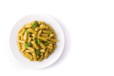 Beyaz arka plan üzerinde izole bir tabak üzerinde pesto sos lu penne makarna ve fesleğen. Üst te. Copyspace