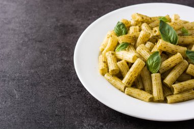 Siyah arka plan üzerinde pesto soslu Penne makarna. Copyspace