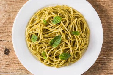 Ahşap masada pesto soslu spagetti makarna. Üst te. Yakın çekim