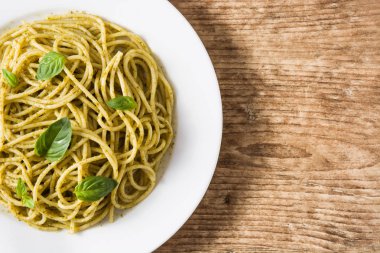 Ahşap masada pesto soslu spagetti makarna. Üst te. Copyspace