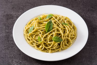 Siyah arka plan üzerinde pesto soslu spagetti makarna. 