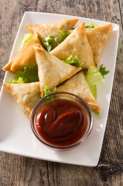 Samsa veya samosas ahşap masada et ve sebze ile . Geleneksel Hint yemekleri.