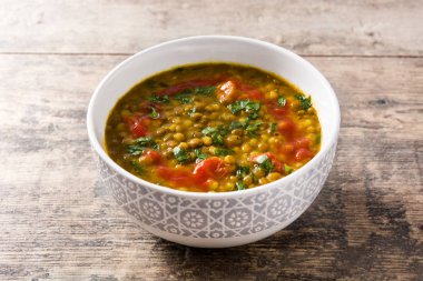 Ahşap masada bir kase Hint mercimek çorbası dal (Dhal)