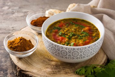 Ahşap masada bir kase Hint mercimek çorbası dal (Dhal)