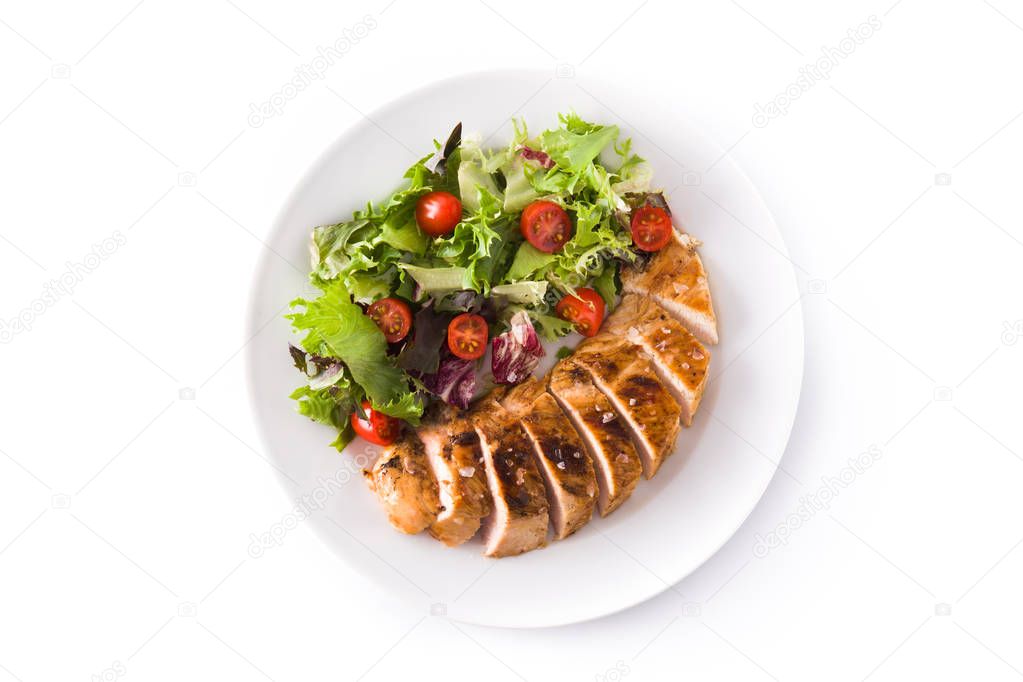 Grilled chicken breast with vegetables on a plate isolated on white background. Top view. 