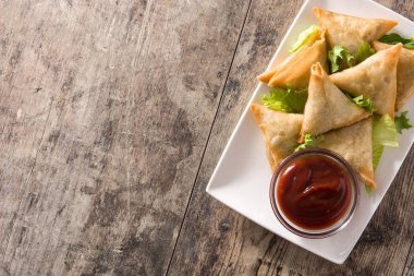 Samsa veya samosas ahşap masada et ve sebze ile. Geleneksel Hint yemekleri. Üst te. Copyspace