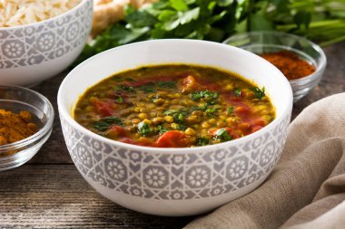 Ahşap masada bir kase Hint mercimek çorbası dal (Dhal). 