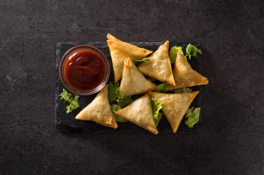 Samsa ya da siyah arka planda et ve sebze ile samosas. Geleneksel Hint yemekleri. Üst görünüm.