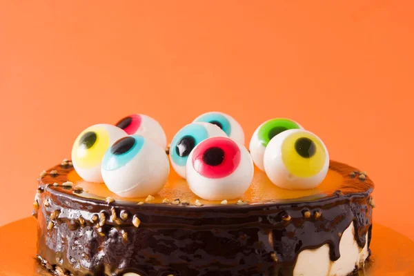 Halloween Kuchen Mit Bonbonaugen Dekoration Auf Orangefarbenem Hintergrund Kopierraum — Stockfoto