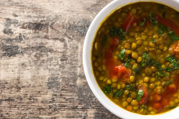 Indian lentil soup dal (dhal) in a bowl on wooden table. Top view. Copyspace