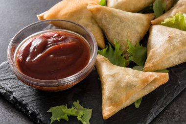 Samsa veya samosas siyah arka plan üzerinde et ve sebze ile. Geleneksel Hint yemekleri.