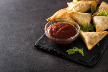 Samsa veya samosas siyah arka plan üzerinde et ve sebze ile. Geleneksel Hint yemekleri. Copyspace
