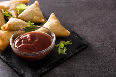 Samsa veya samosas siyah arka plan üzerinde et ve sebze ile. Geleneksel Hint yemekleri. Copyspace