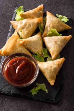 Samsa ya da siyah arka planda et ve sebze ile samosas. Geleneksel Hint yemekleri. Üst görünüm.