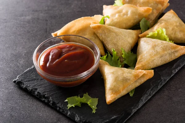 Samsa veya samosas siyah arka plan üzerinde et ve sebze ile. Geleneksel Hint yemekleri.