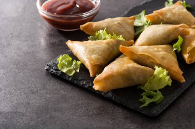 Samsa veya samosas siyah arka plan üzerinde et ve sebze ile. Geleneksel Hint yemekleri. 